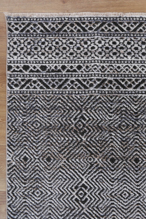 Black and white geometric patterned rug on wooden floor