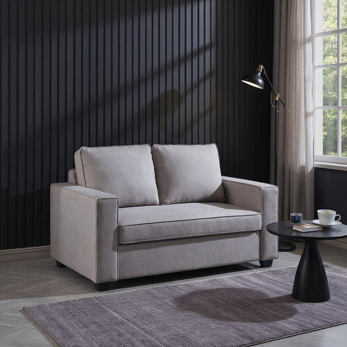 Modern gray two-seater sofa in stylish living room with black panel wall and side table