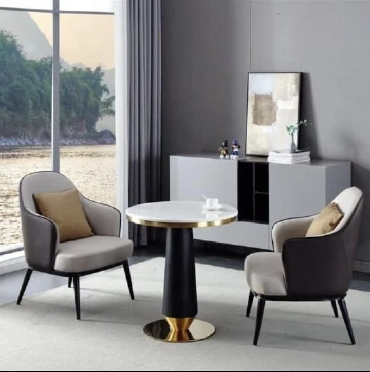 Modern living room with two armchairs, round marble coffee table, and sideboard