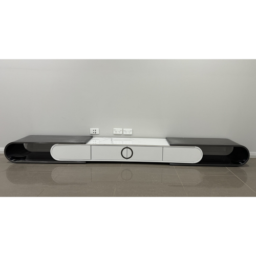 Modern TV unit with white marble top and black glossy sides, featuring circular handle design