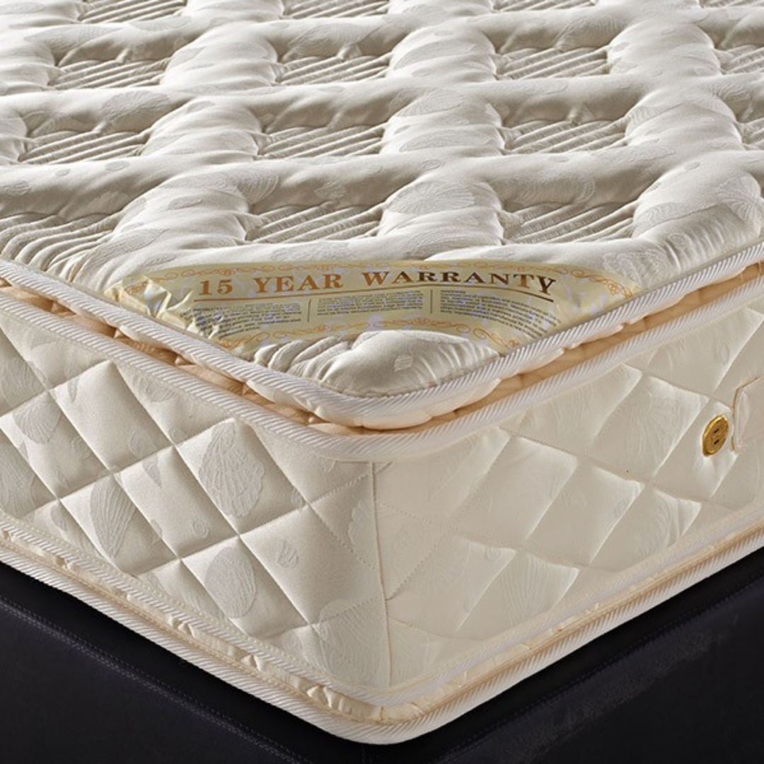 Close-up of a plush, quilted cream mattress with a 15 year warranty label, home furniture