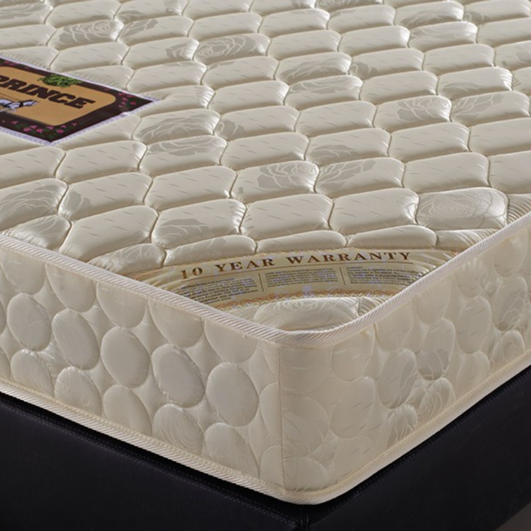 Close-up of a quilted beige mattress with 10-year warranty label, placed on a bed base