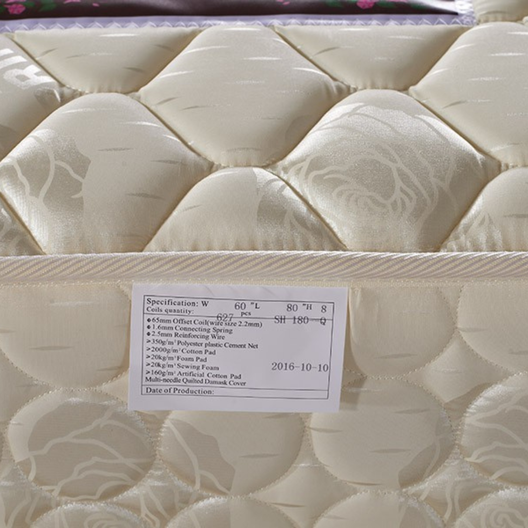 Close-up of a quilted beige mattress with product specifications label attached.