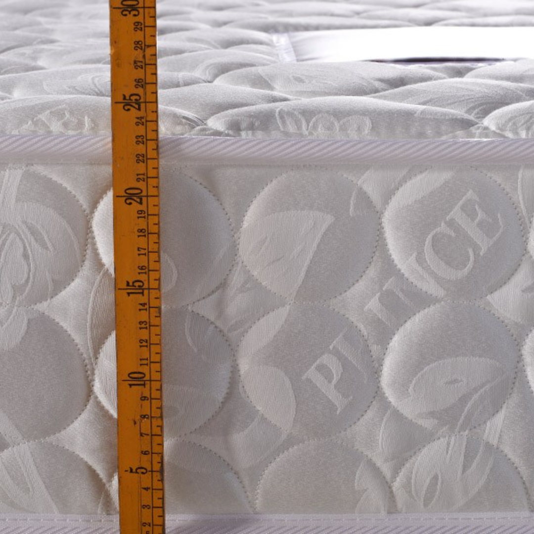 Close-up of white quilted mattress thickness measured with ruler