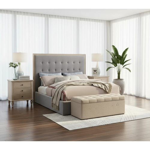 Modern bedroom with grey upholstered bed, beige bench, wood nightstands, and potted plant