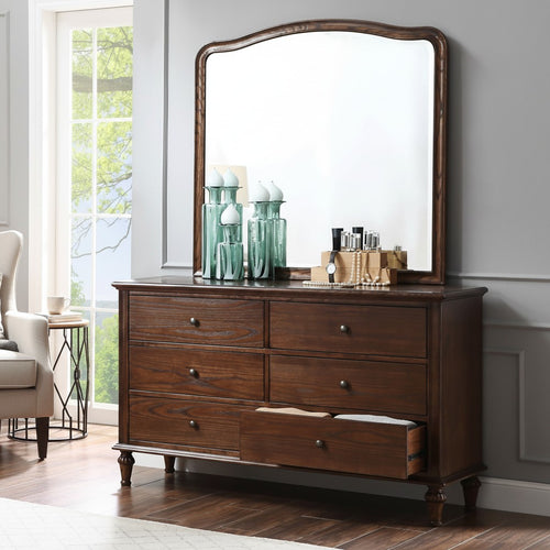Wooden dresser with mirror, decorative vases, and storage drawers in a bright bedroom