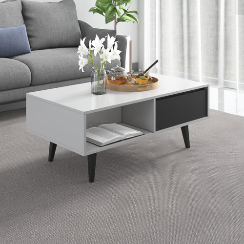 Modern white coffee table with gray drawer and open shelf, styled with flowers and tea set in living room