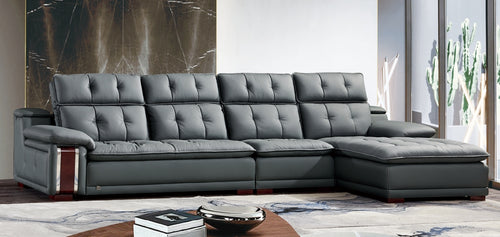 Modern grey leather sectional sofa with chaise, tufted back, in stylish living room setting