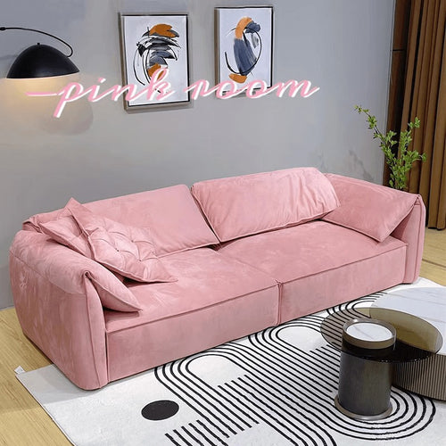 Pink velvet sofa in modern living room with abstract art and geometric rug