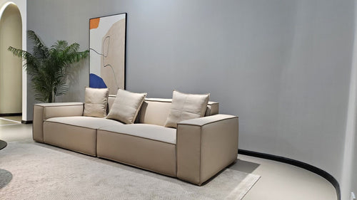 Modern beige sectional sofa with plush cushions in minimalist living room setting