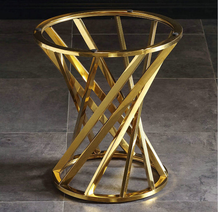 Modern gold metal side table base with geometric twist design on a tiled floor