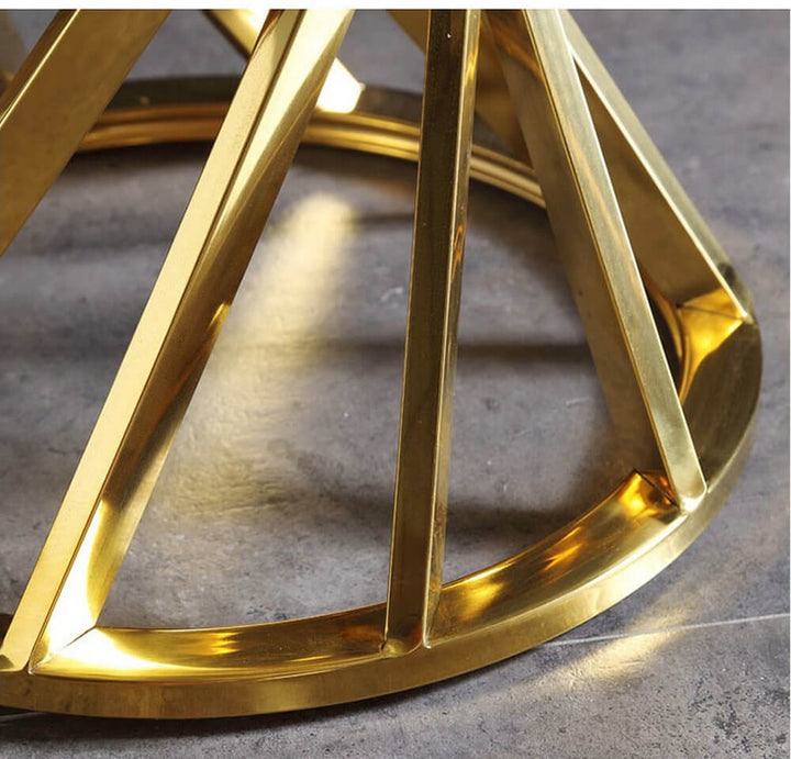 Close-up of modern gold metal side table base on gray floor