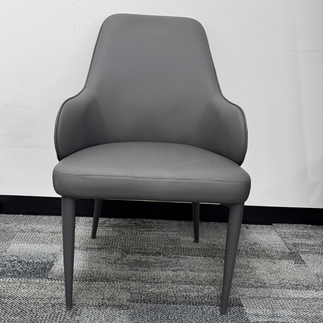 Modern gray upholstered dining chair with slim legs on carpeted floor