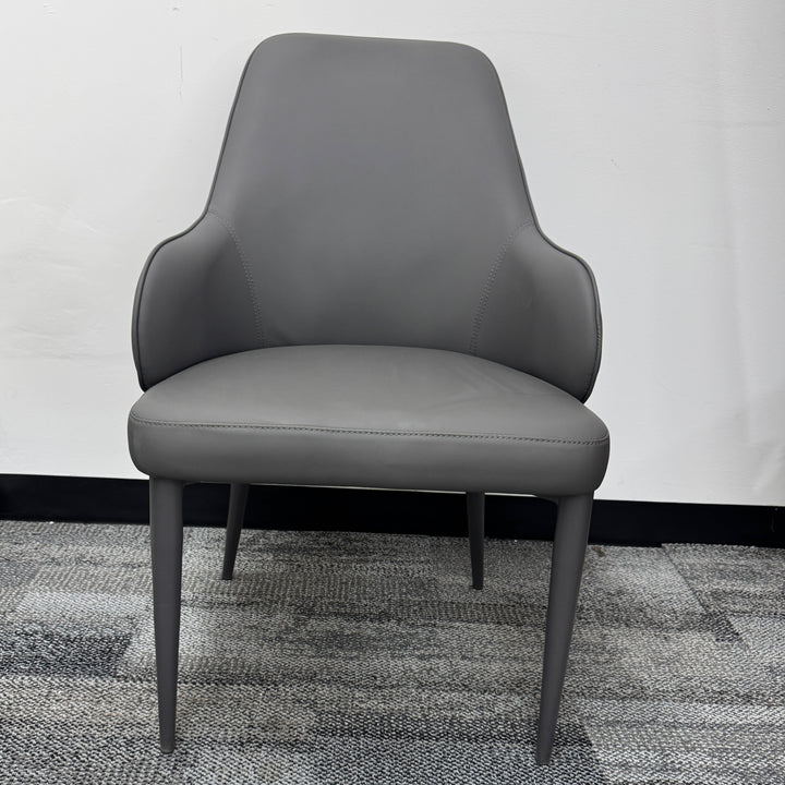 Modern gray upholstered dining chair with slim legs on carpeted floor