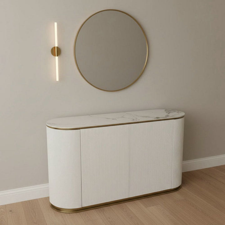 Modern white and gold sideboard with marble top, round mirror, and wall light in minimalist room