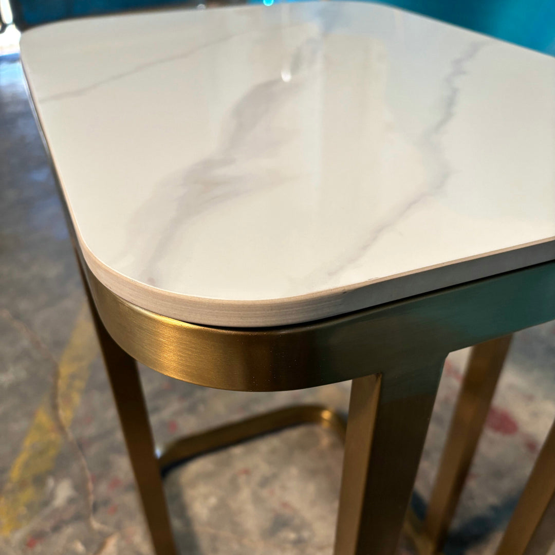 Modern marble-top table with gold metal legs in a contemporary indoor setting