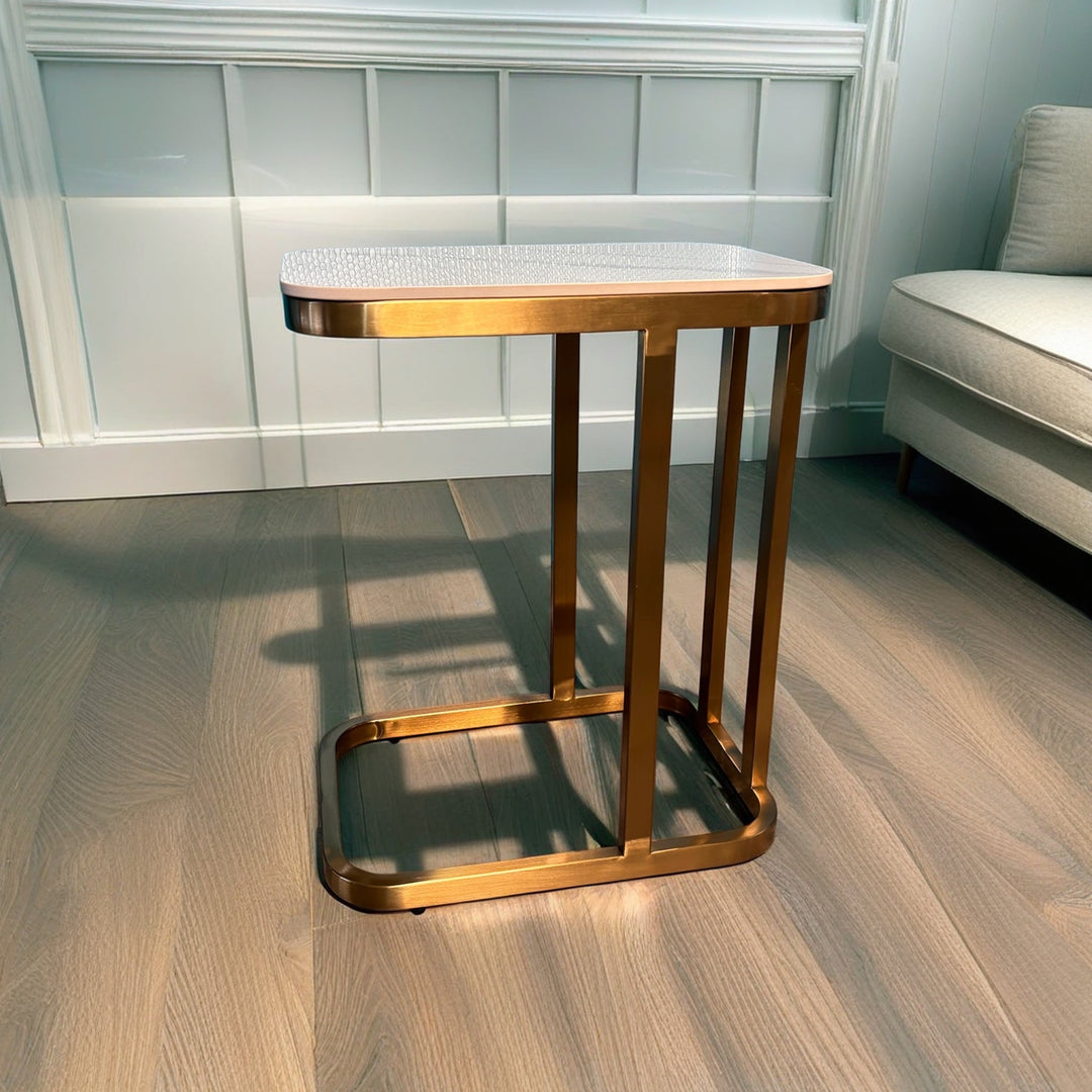 Modern gold metal side table with textured white top in a living room setting