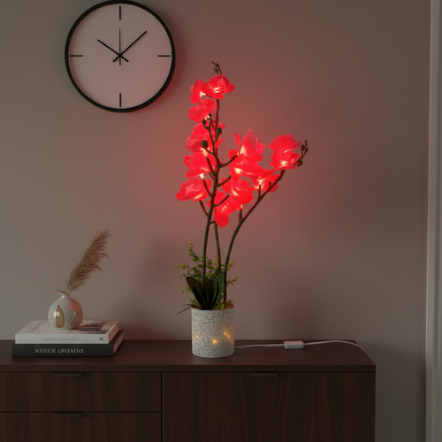 Glowing red LED orchid lamp on wooden sideboard, modern home decor with wall clock