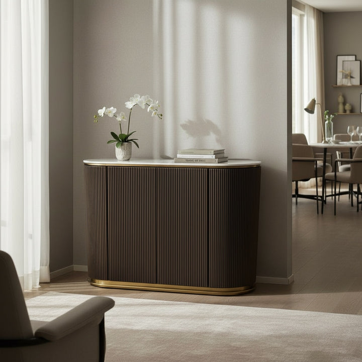 Modern wood sideboard with gold trim in a bright living room, orchid plant and books on top.