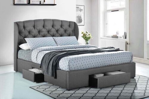 Grey tufted bed frame with storage drawers, styled with patterned bedding in modern bedroom