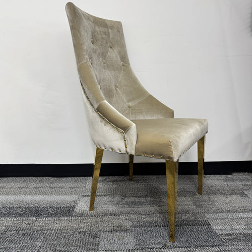 Velvet accent chair with tufted backrest and gold metal legs on carpeted floor